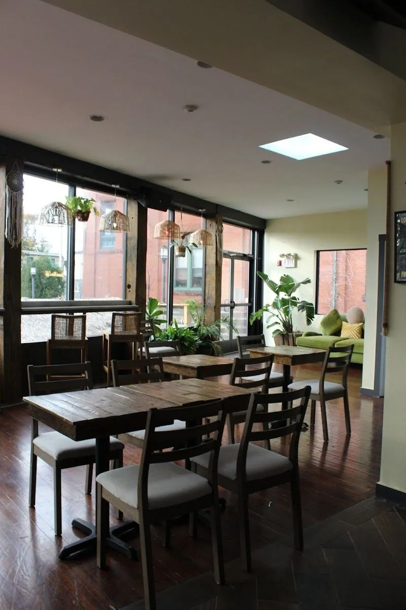 Window seating with plants and green velvet sofa